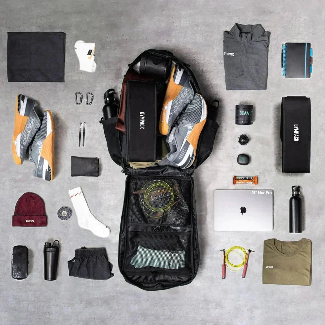 Mochila Gympack Pro 50 Litros Preta - Mochila Aberta no Centro Mostrando Diversos Itens que Cabem Facilmente